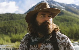 Mann mit Vollbart Cowboyhut in der Natur